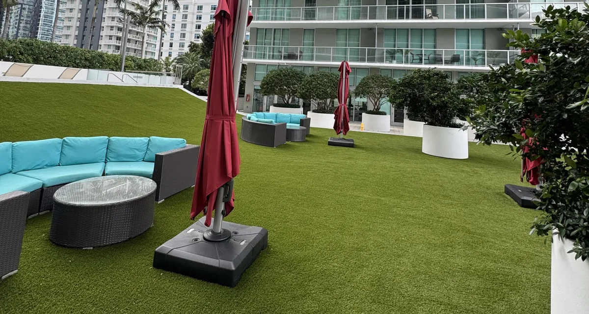 Artificial turf installed across a shared community terrace with seating areas
