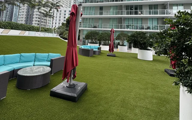 Artificial turf installed across a shared community terrace with seating areas