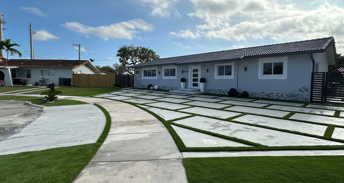 Expansive open backyard turf lawn bordered by wood rail fencing and mature landscaping