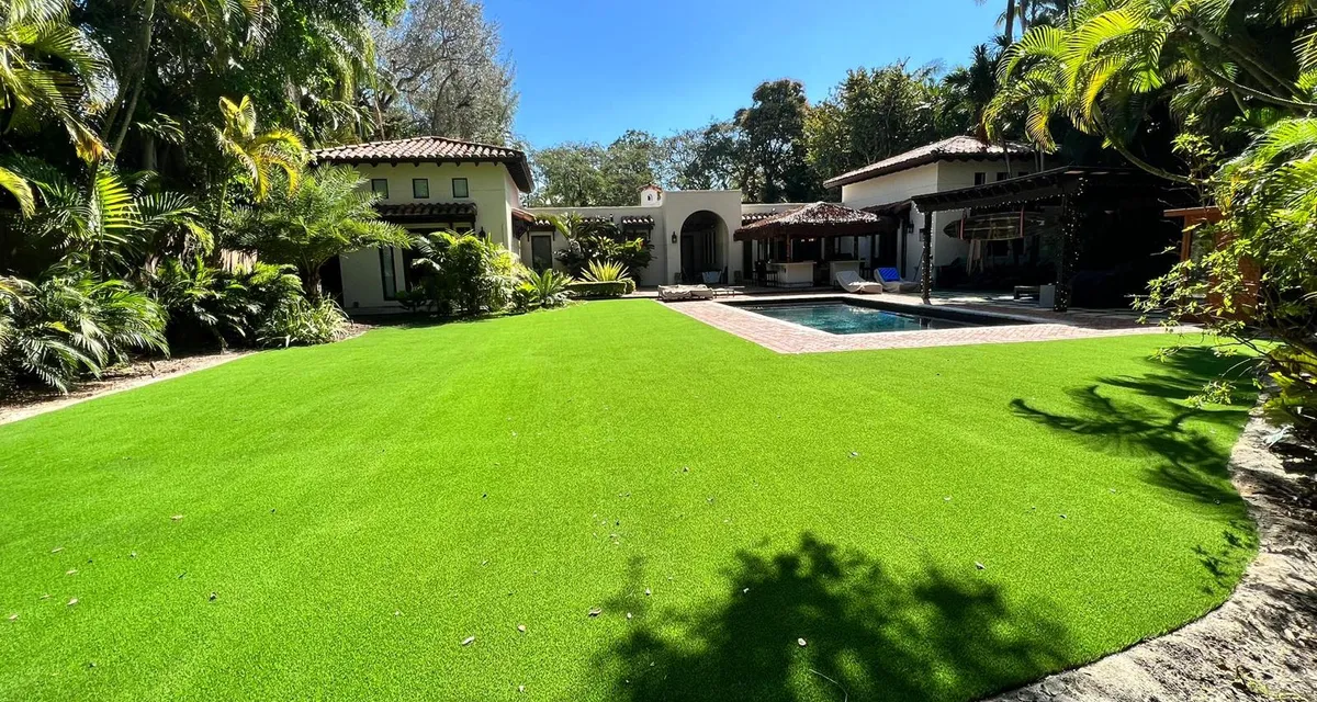 Lush, evenly green artificial turf backyard lawn under bright South Florida sun