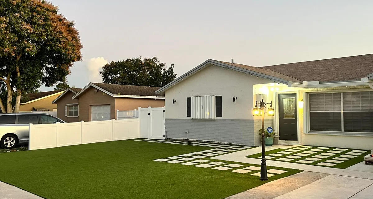 Artificial turf front lawn with a clean, even edge along the driveway
