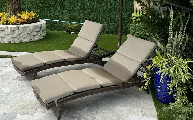 Artificial turf lawn bordering a paver patio with outdoor seating near a grill area