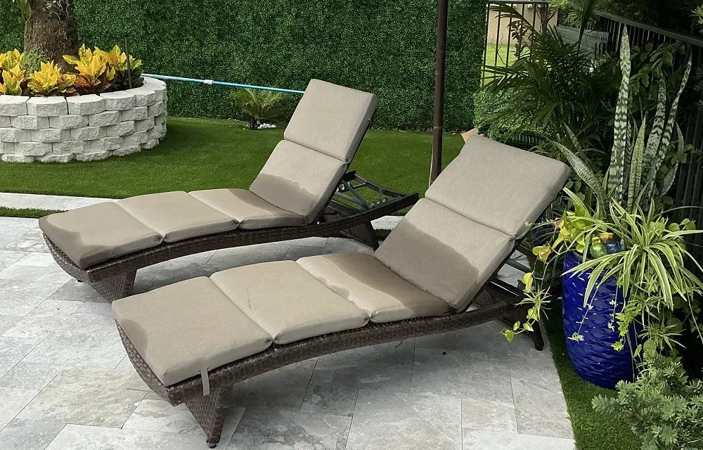 Fenced patio lawn with artificial turf bordered by pavers and tropical landscaping