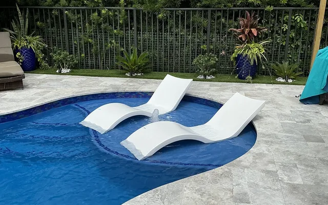 Artificial turf lawn bordering a pool patio near open water