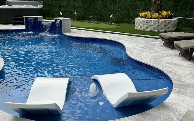 Artificial turf lawn beside a pool deck with no standing water or bare, muddy patches