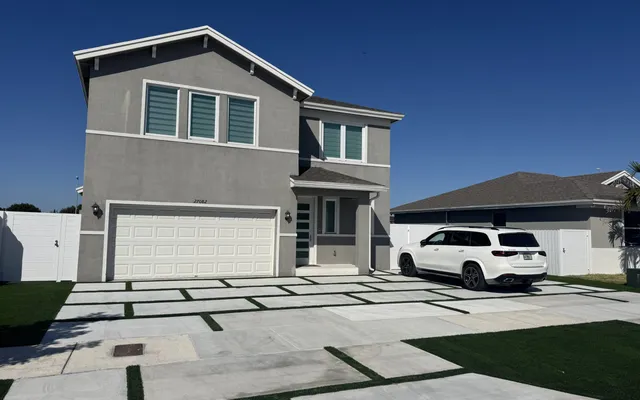 Narrow side-yard artificial lawn running beside a paver walkway toward a pool deck