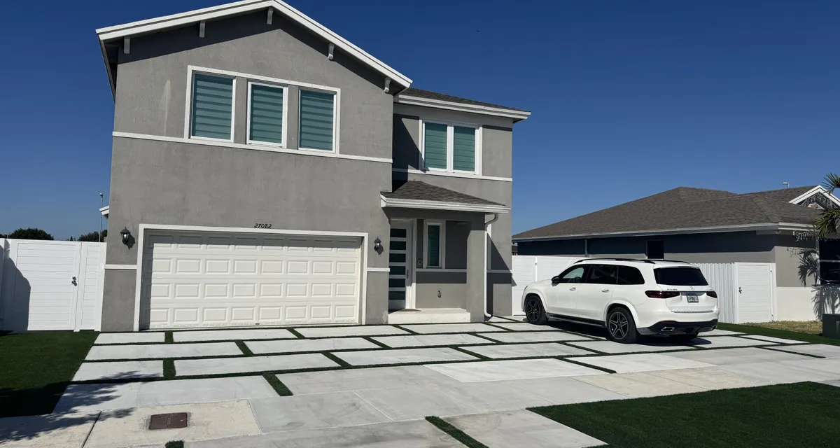 Narrow side-yard artificial lawn running beside a paver walkway toward a pool deck