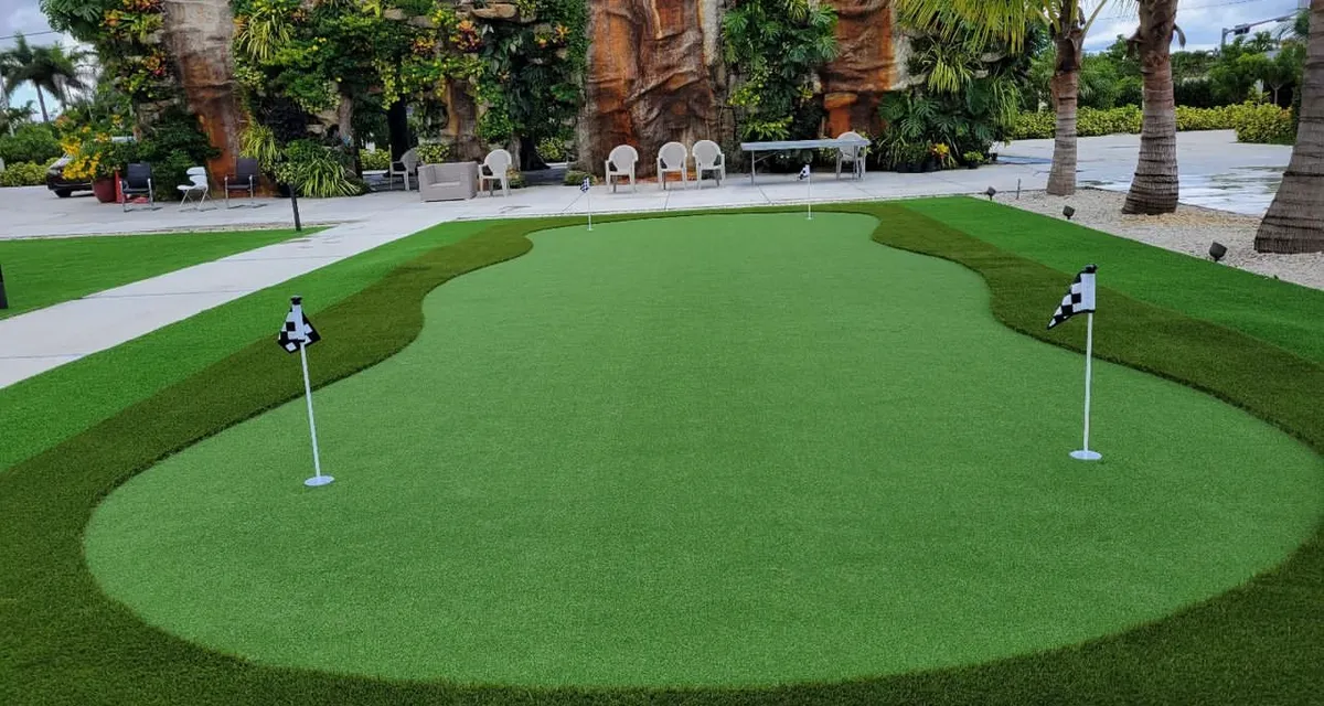 Lush artificial grass yard installed by Govorex with clean edging along a paver walkway