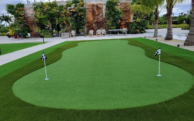 Lush artificial grass yard installed by Govorex with clean edging along a paver walkway